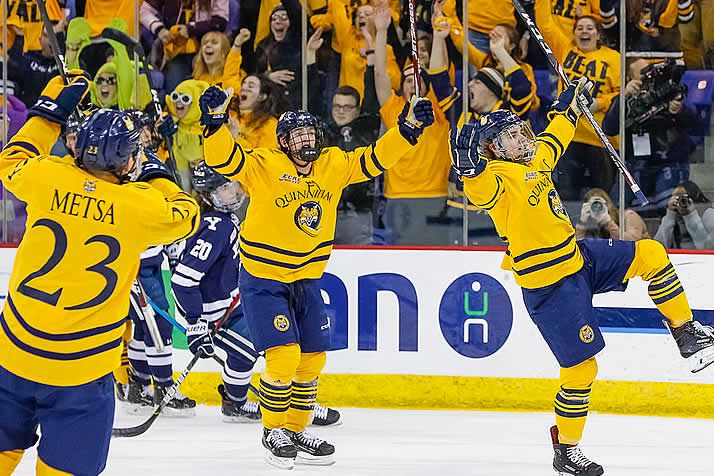 Jugadores de hockey sobre hielo de Quinnipiac celebrando un gol.